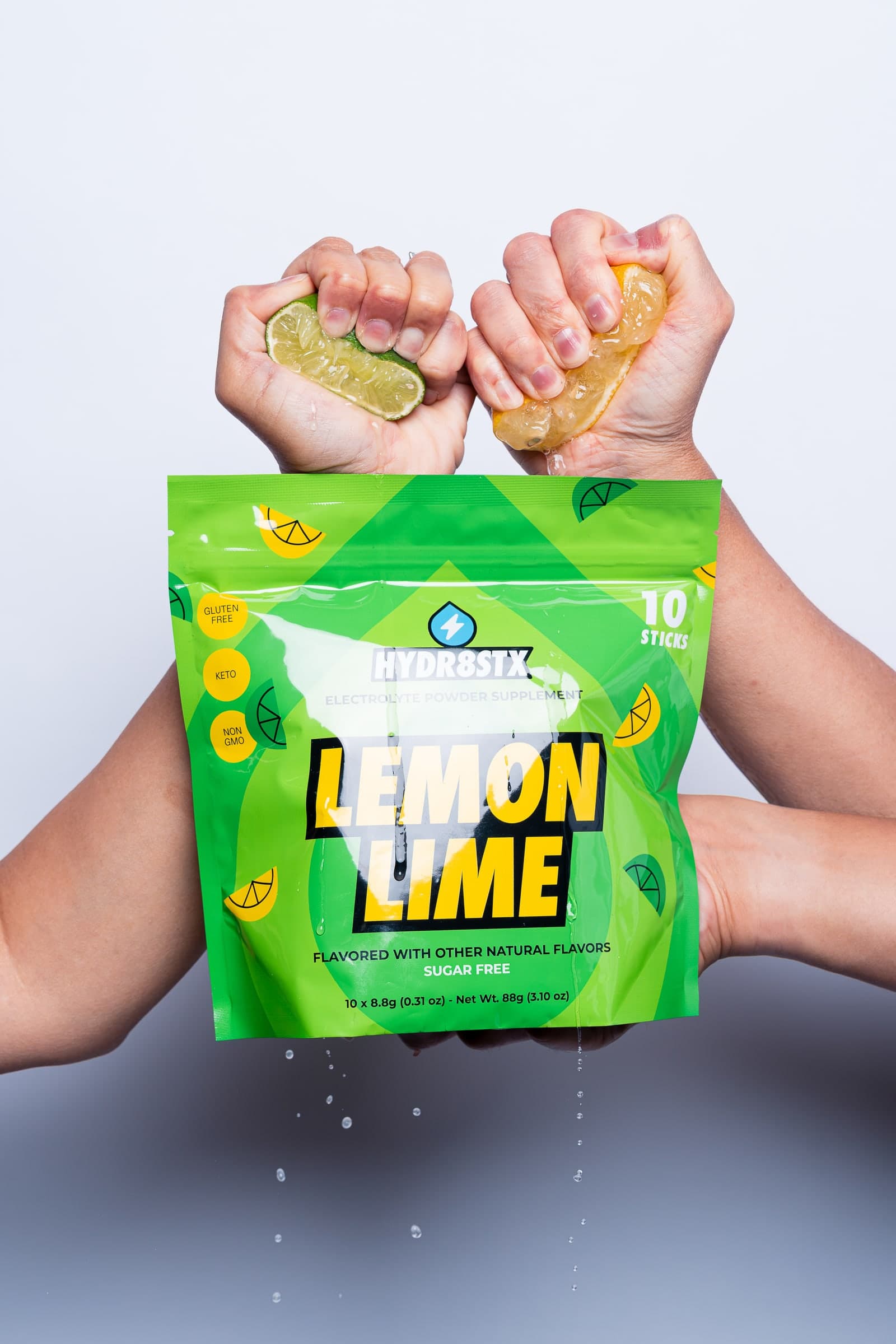 Fresh lemon, lime, and pineapple being squeezed over Hydr8Stx pouches